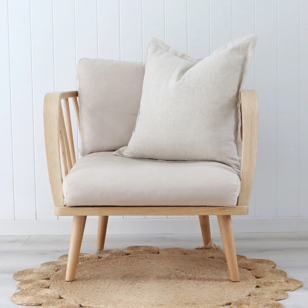 A natural cushion sitting upright on a light coloured seat.