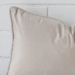 Corner section image showing features of rectangle natural cushion that is made from velvet fabric.
