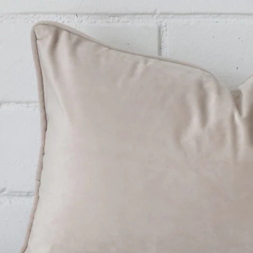 Corner section image showing features of rectangle natural cushion that is made from velvet fabric.