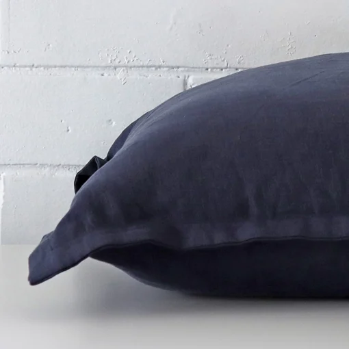 A side view of navy cushion that has linen fabric and a square size.