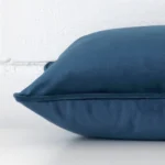 A side view of navy cushion that has velvet fabric and a rectangle size.
