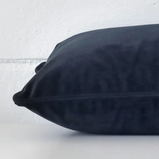 Close side shot of this navy velvet cushion cover. It is a rectangle design.
