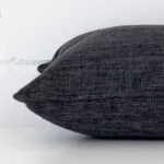 A side view of charcoal cushion that has linen fabric and a rectangle size.