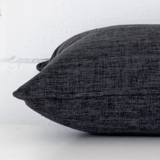 A side view of charcoal cushion that has linen fabric and a rectangle size.