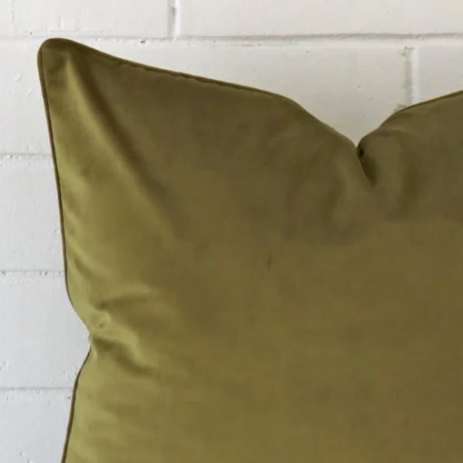 Corner section image showing features of large olive cushion that has velvet fabric.