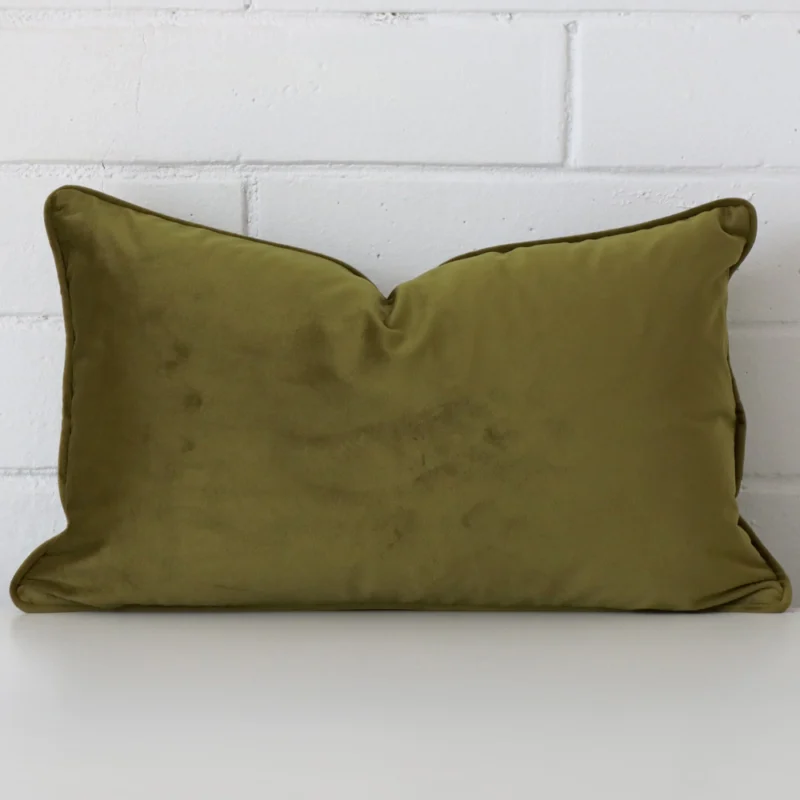 olive-velvet-rectangular-cushion-cover-30cm-x-50cm-sc769-30 Olive cushion cover in front of a white wall. It has a rectangle size and is made from a velvet material.
