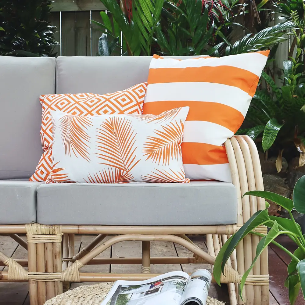 Orange outdoor cushions arranged on seating outside.