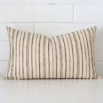 Rectangle striped cushion cover sitting upright in front of a brick wall. It has been made from a quality designer material.