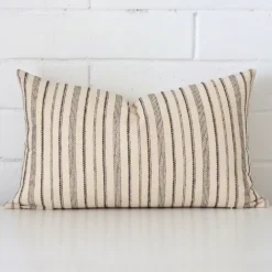 Rectangle striped cushion cover sitting upright in front of a brick wall. It has been made from a quality designer material.