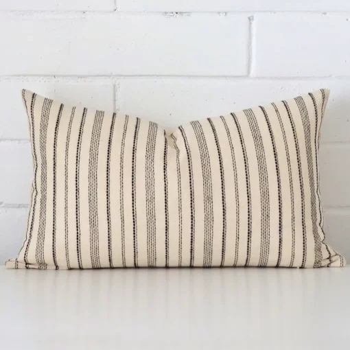 Rectangle striped cushion cover sitting upright in front of a brick wall. It has been made from a quality designer material.