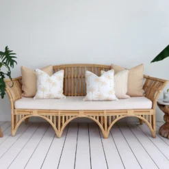 An inviting outdoor lounge area featuring a comfortable seat adorned with beige cushions.