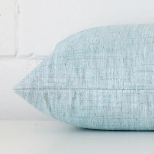 Side angle shot of linen rectangle cushion cover. The duck egg hue is shown close up.