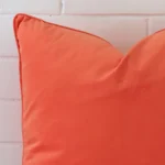 Corner image of peach velvet cushion over