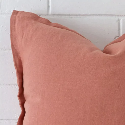 A detailed shot of this pink cushion cover that has linen fabric and a square size.