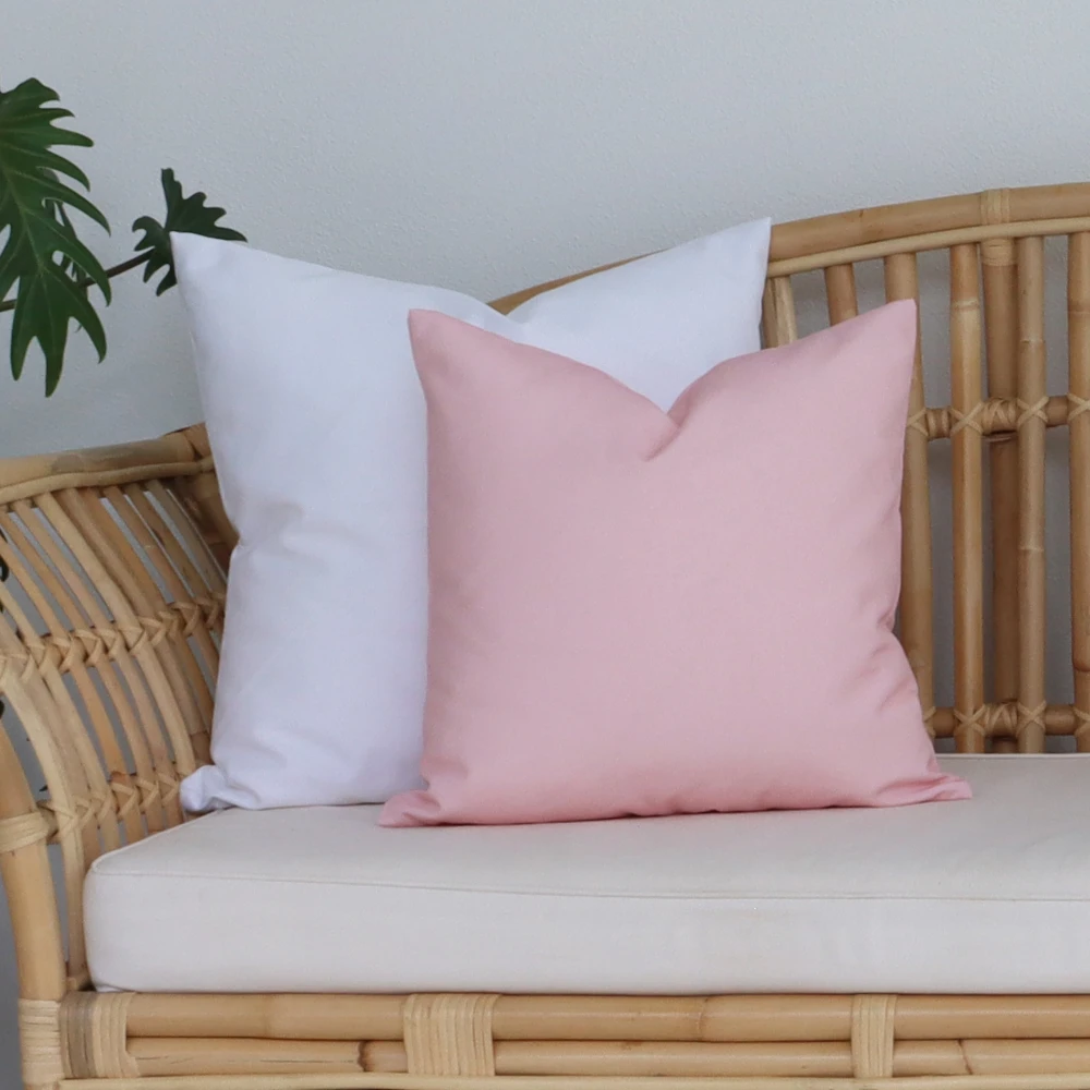 Pink outdoor cushions have been layered tastefully on seating outside.