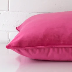 The corner of this velvet square cushion cover is shown close up. The pink colour is shown in greater detail.