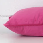 Lateral view of front and back panels of this velvet cushion cover in a rectangle size and with pink colouring.