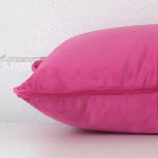 Lateral view of front and back panels of this velvet cushion cover in a rectangle size and with pink colouring.