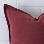 Magnified view of this linen plum cushion cover’s corner showing its square size.