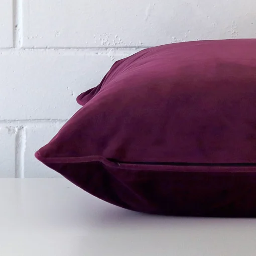 Side perspective showing seam of large purple cushion cover that has velvet fabric.