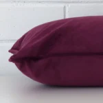 Lateral viewpoint of this velvet rectangle cushion. The purple colour is shown from the side showing the front and rear panels.