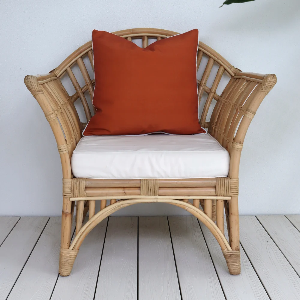 A red outdoor cushion is sitting on a single chair.