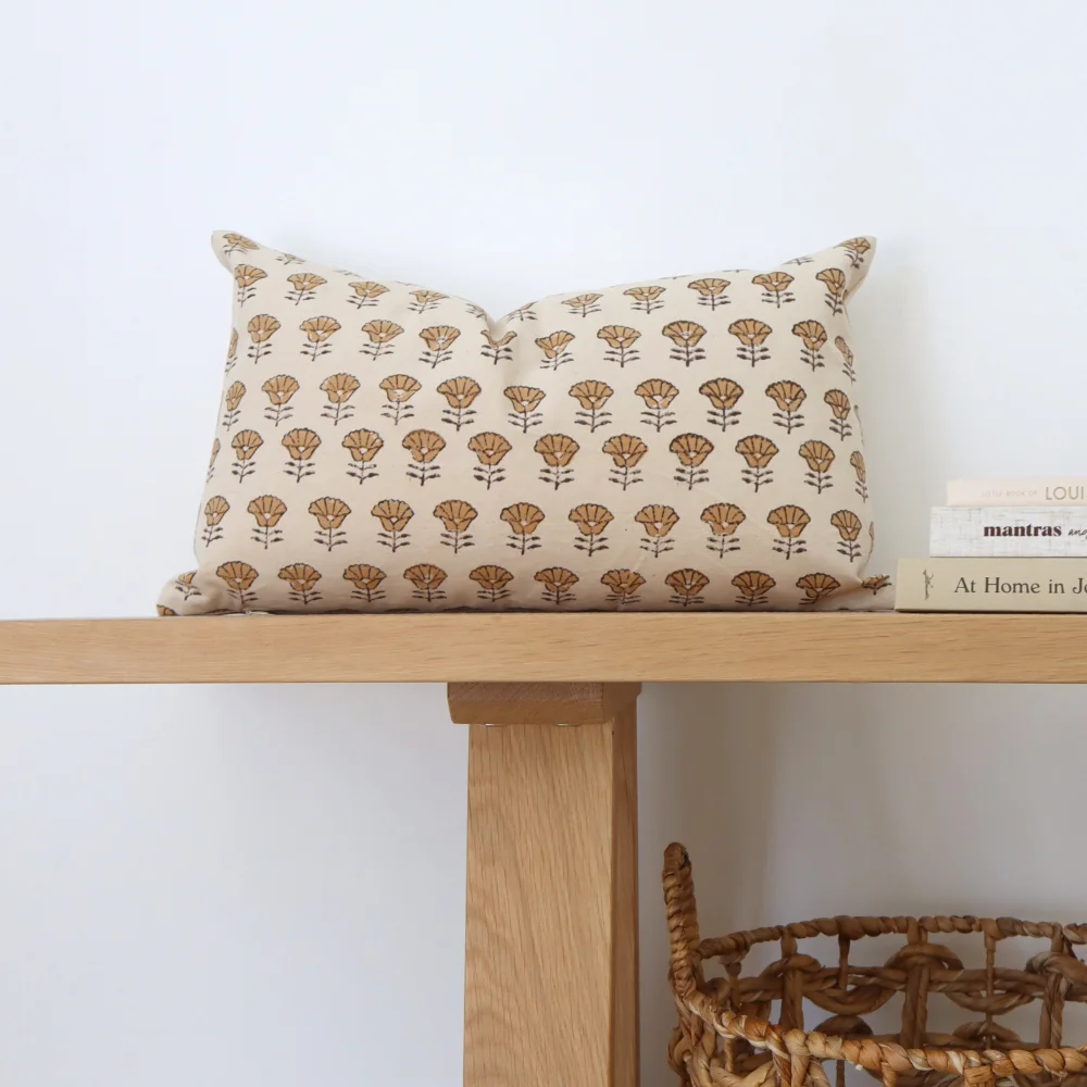 A retro cushion is showcased on a light coloured bench seat.