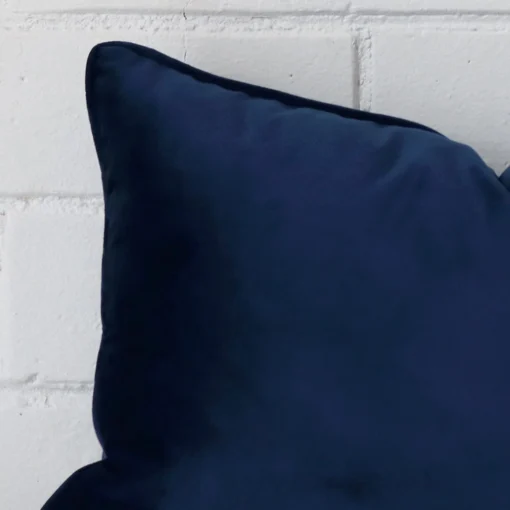 A macro image of the top left corner of this velvet cushion. It is possible to see the finer detail of the rectangle shape and royal blue colour.