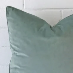 A macro image of the top left corner of this velvet cushion. It is possible to see the finer detail of the square shape and spearmint colour.