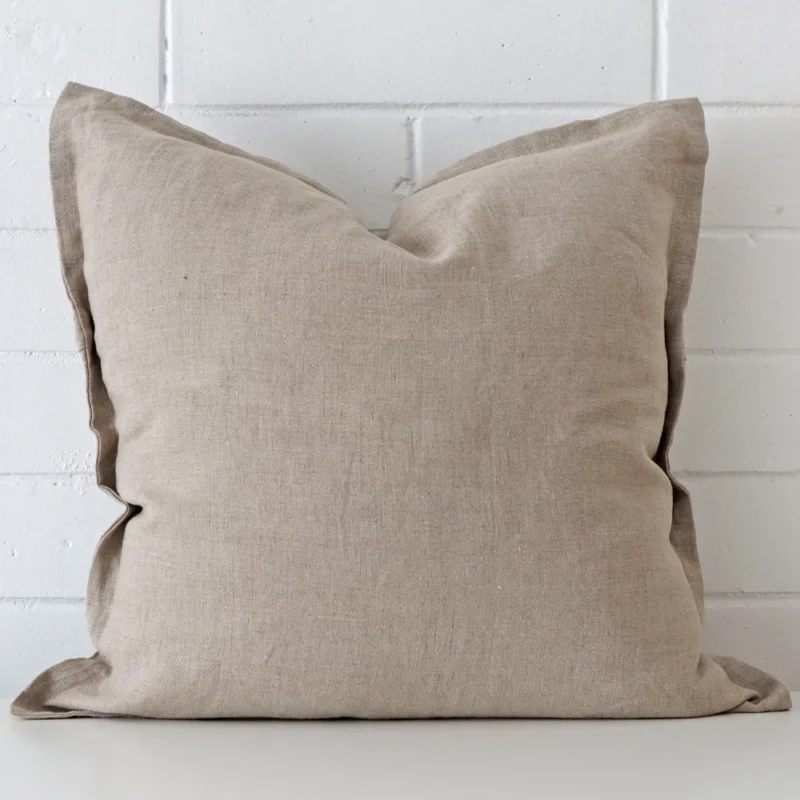 Close up view showing a corner of this linen cushion in a square size and with stone colouring.