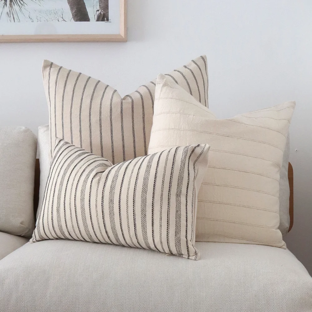 Three striped cushions arranged on a seat by size.