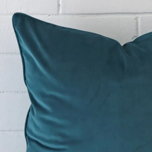 Close up image of velvet large cushion. The image allows you to see the teal hue more thoroughly.