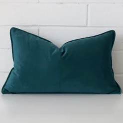 Rectangle cushion cover in velvet colour sitting upright in front of a brick wall. It has been made from a quality velvet material.