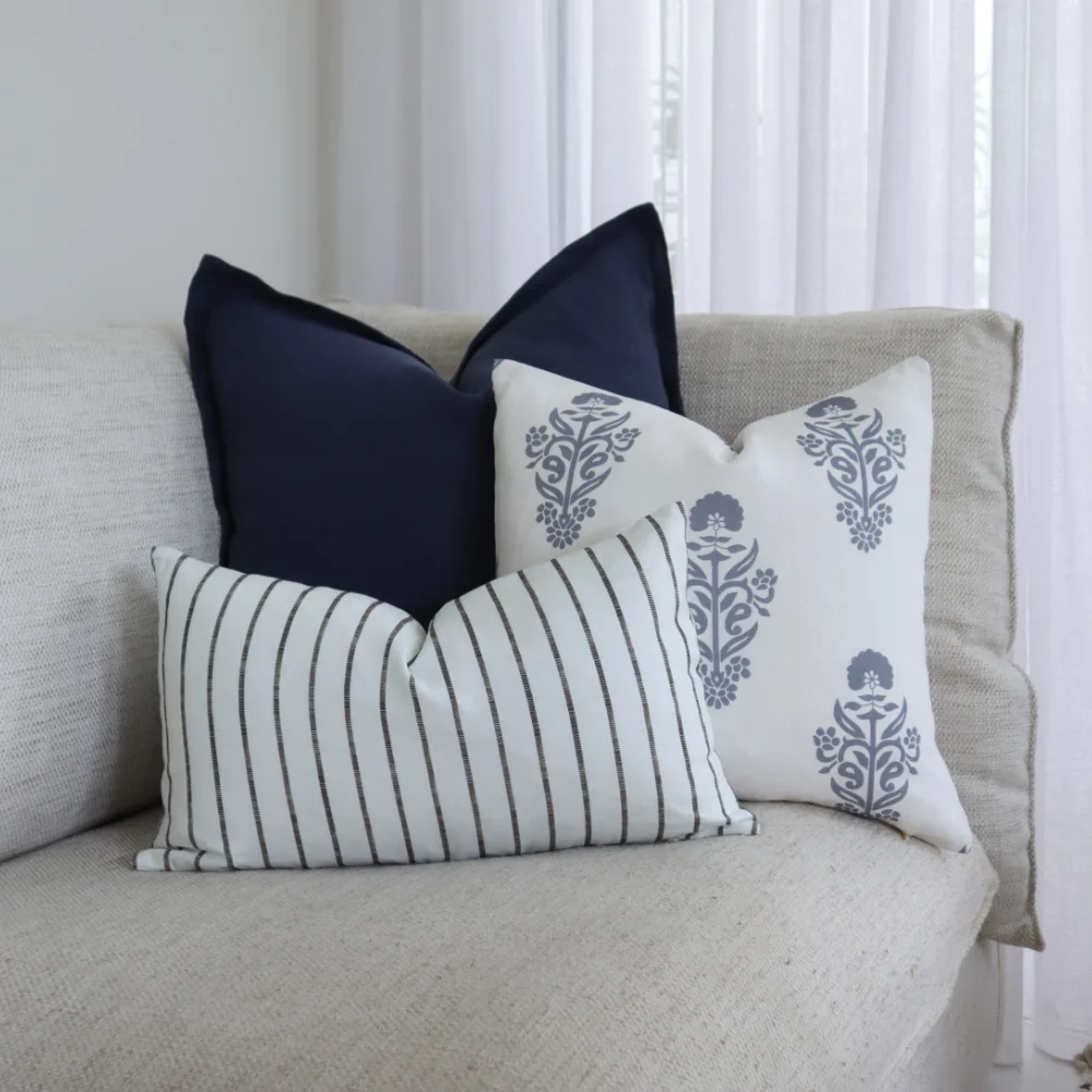A group of throw cushions styled on seating near a window.