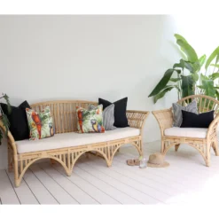 Some lovely black and parrot-printed outdoor cushions are arranged neatly on a rattan seat adding a fun and stylish vibe to the outdoor area.