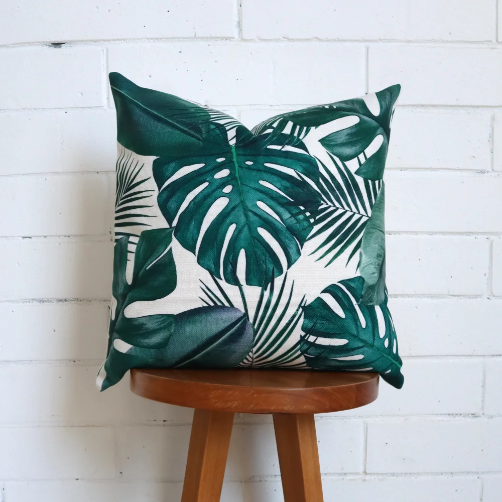 A tropical cushion styled on a tall timber stool.