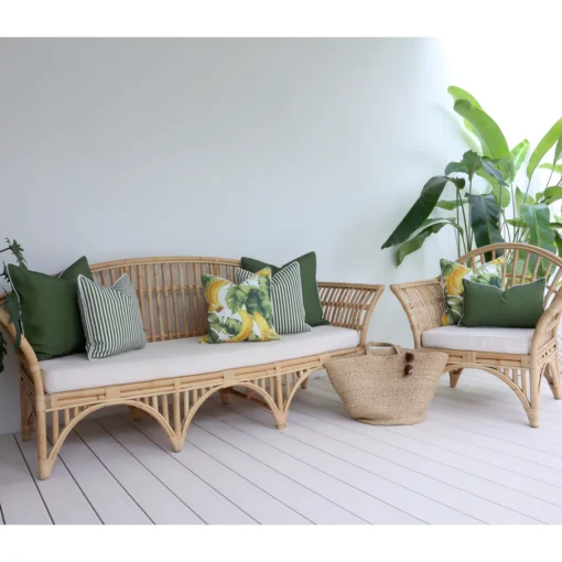 Seven olive cushions on an outdoor sofa nestled amidst vibrant greenery.