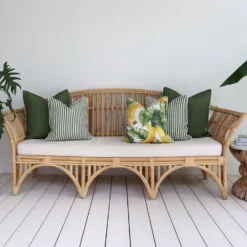 Five olive-coloured outdoor cushions adorn a rattan seat creating a flawless fusion.