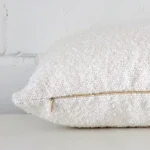 Lateral view of front and back panels of this boucle cushion cover in a rectangle size and with white colouring.