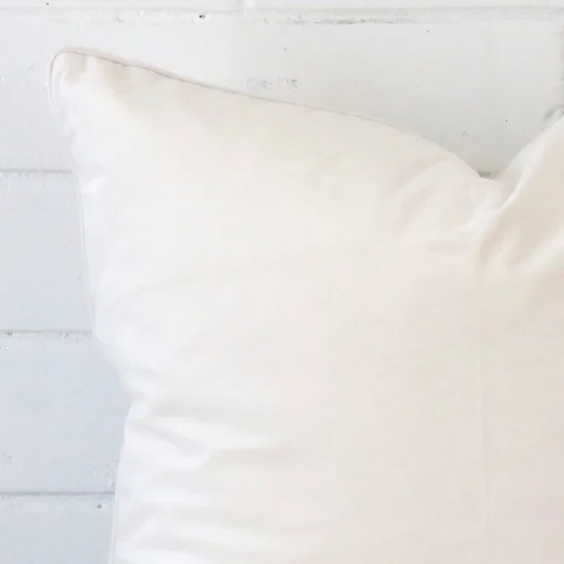 Close range image of white cushion. The large size and velvet material can be seen in detail.