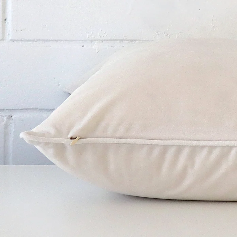 Large cushion cover in white colour sitting flat. The sideways viewpoint shows the seams of the velvet material.