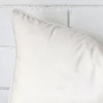 Focused view of rectangle cushion cover. The shot shows details of its velvet material and white colour.