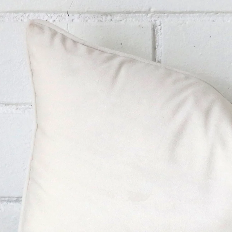 Focused view of rectangle cushion cover. The shot shows details of its velvet material and white colour.