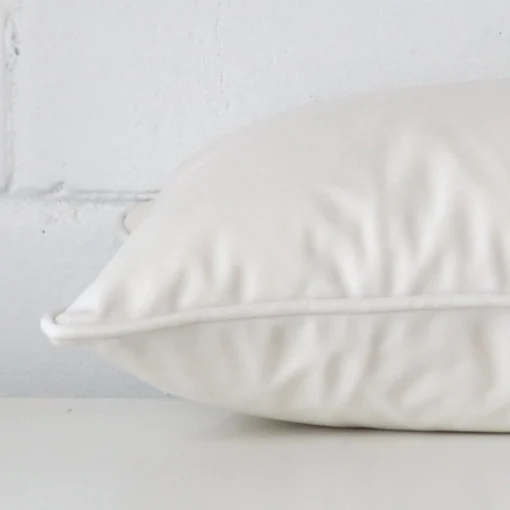 White cushion cover laid on its back side. The image shows a side-on view of the velvet material and its rectangle dimensions.