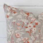 A macro image of the top left corner of this floral linen cushion. It is possible to see the finer detail of the square shape and grey colour.