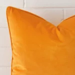 Focused view of large cushion cover. The shot shows details of its velvet material and yellow colour.