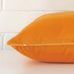 Yellow cushion cover laid on its back side. The image shows a side-on view of the velvet material and its large dimensions.