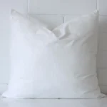 45x45 cushion insert with faux feather microfibre filling positioned against a white wall. The insert is sized at 45 x 45 cm.