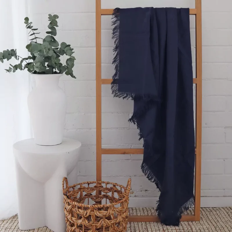 Navy Linen Throw - TH816 A navy linen throw displayed in a white room with a wooden rack.