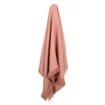 A lovely pink linen throw hanging on a hook.
